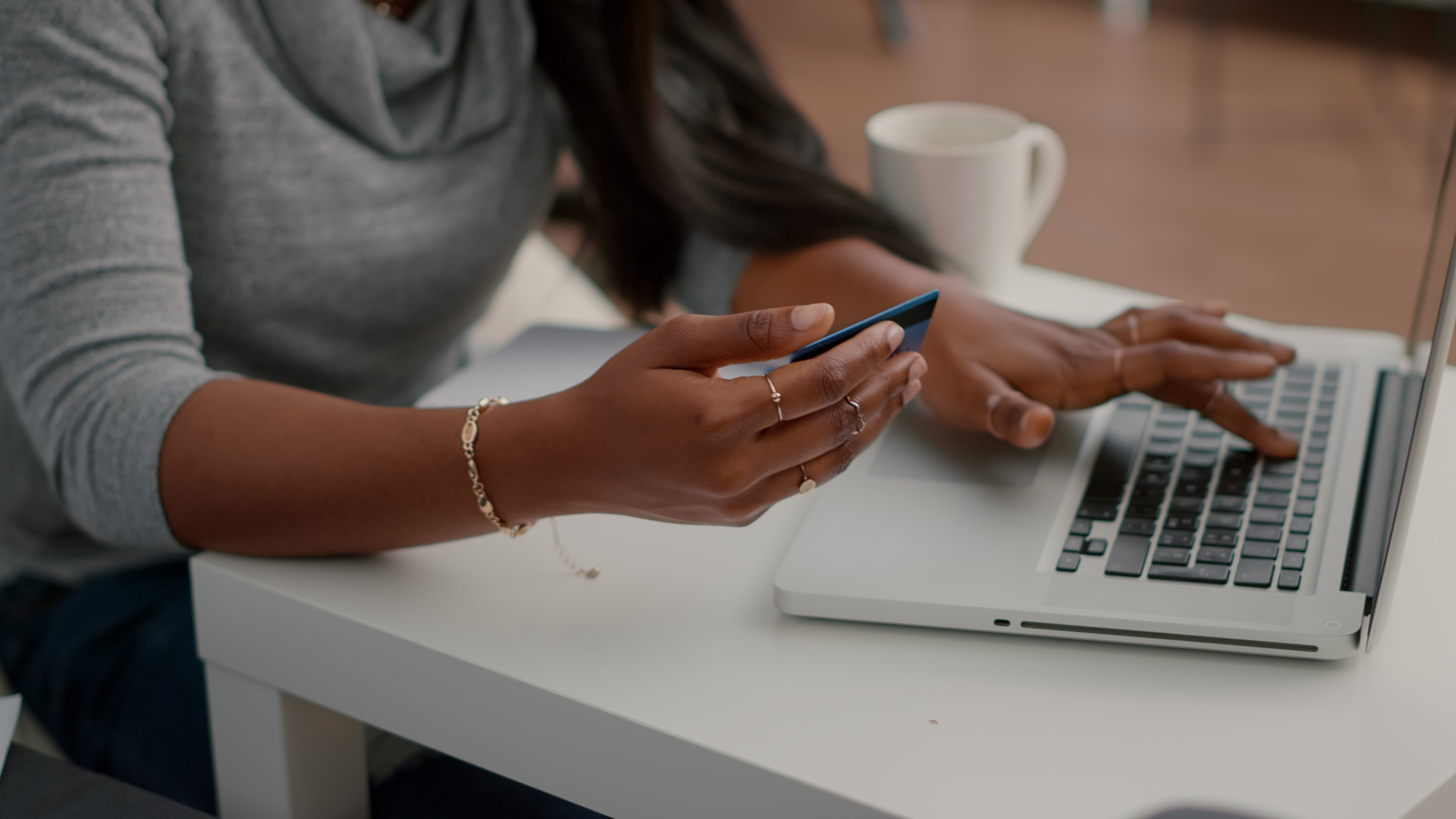 student holding credit card doing electronic transaction searching online store